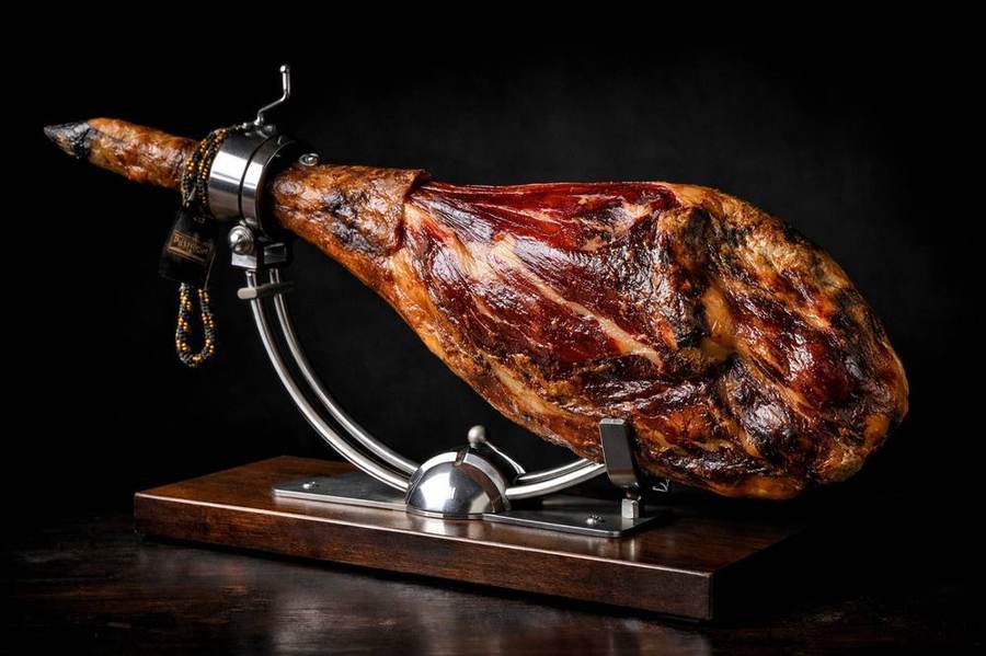 Whole Jamón 100% Ibérico de Bellota on professional stand