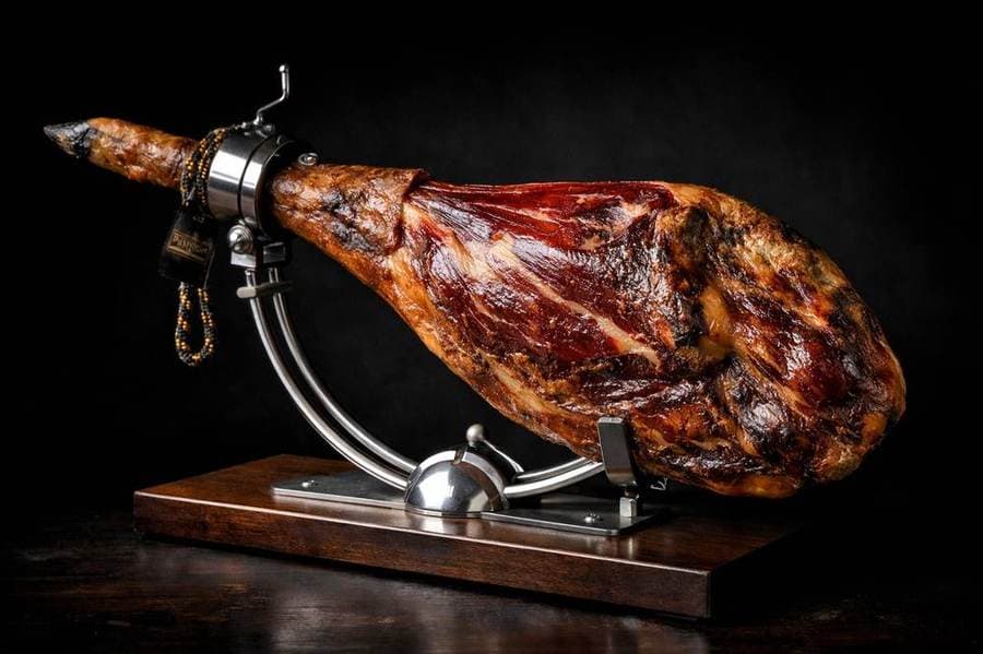 Whole Jamón 100% Ibérico de Bellota on professional stand